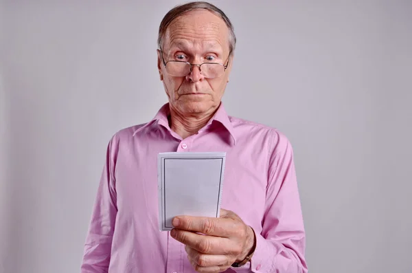 Schockierter Geschäftsmann vor grauem Hintergrund beim Lesen einer teuren Rechnung — Stockfoto