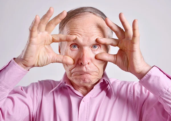 Augen auf! Älterer Mann auf grauem Hintergrund — Stockfoto