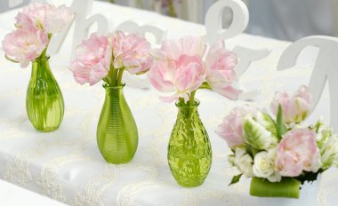 Pink flowers in green glass vases clipart
