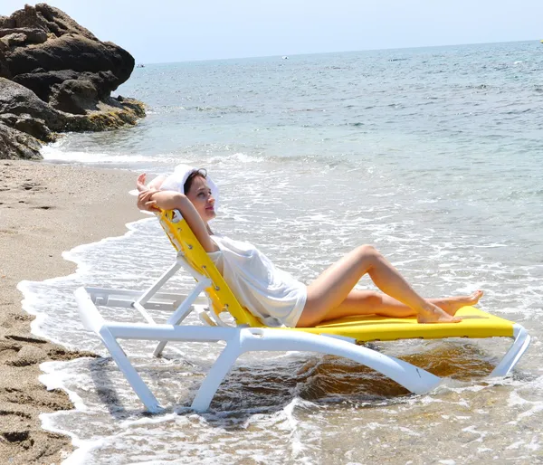 Štíhlá dívka na lehátko relaxační na pláži — Stock fotografie