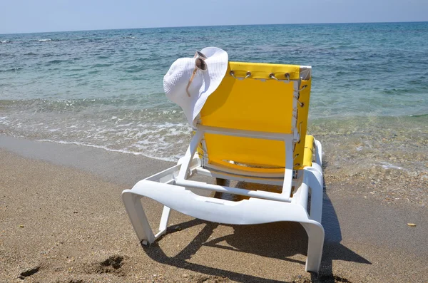 Fauteuil jaune avec chapeau blanc sur elle avec fond de mer — Photo