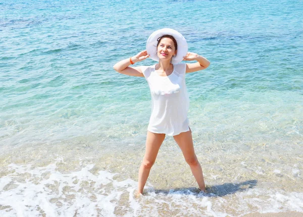 Lykkelig heiagjengjente nyter frihetskvinne i fri lykke på stranden. En glad kvinnelig modell i hvit sommerkjole som nyter naturen i ferieferier utendørs – stockfoto