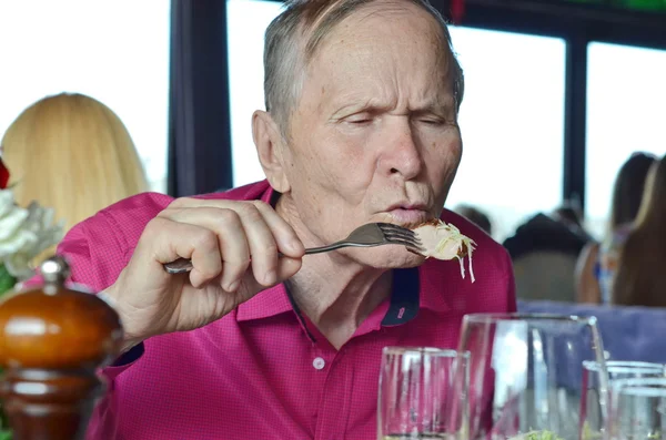 Portrait of senior eating in a restaurant — Stock Photo, Image