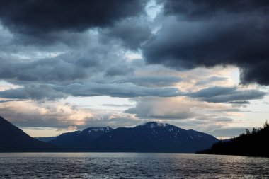 Putorana Platosu Lama Gölü 'nün arka planında dağlar olan gün batımı zamanı..