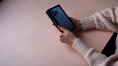 Kadın elleri iPhone 13 'ü açıyor. Bölüm 2 Moskova, Rusya, Aralık 12021.