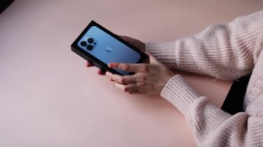 Kadın elleri iPhone 13 'ü açıyor. Bölüm 4 Moskova, Rusya, Aralık 12021.