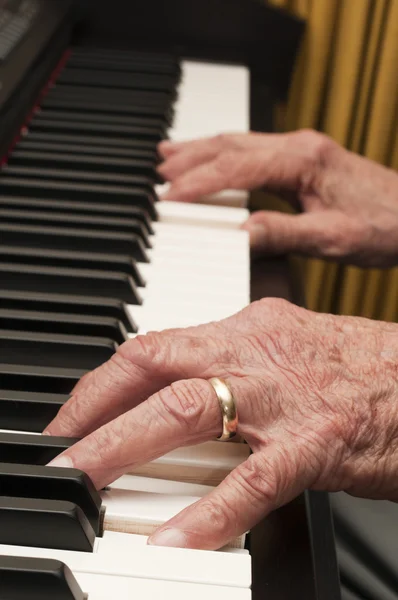 Mãos velhas no piano — Fotografia de Stock