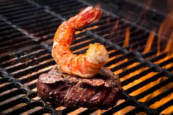 Jumbo garnalen en steak op een grill — Stockfoto