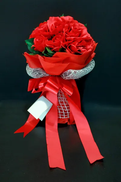 Bouquet de roses rouges avec noeud papillon sur fond noir — Photo
