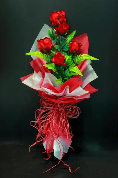 Red rose bouquet with bow tie on black background — Stock Photo, Image
