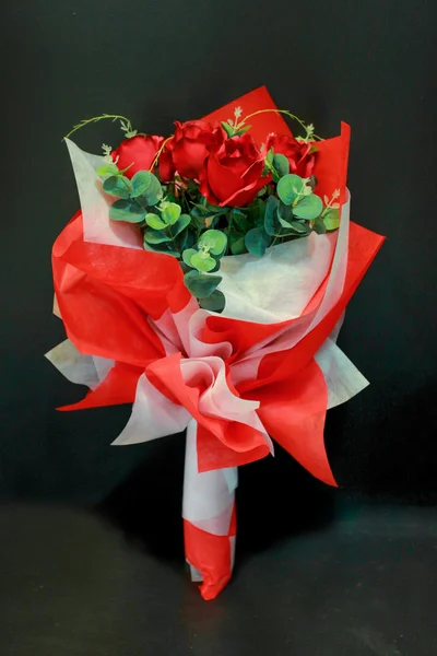 Red rose bouquet with bow tie on black background — Stock Photo, Image