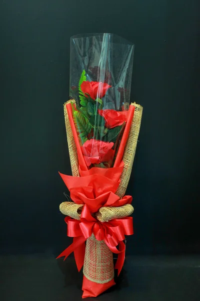 Bouquet de roses rouges avec noeud papillon sur fond noir — Photo