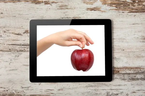 Tablet computer with the hand and a red apple on the screen — Stock Photo, Image