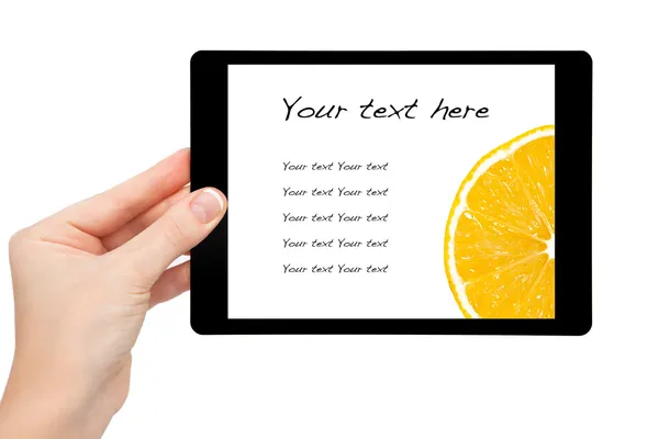 Woman hand hold a mini tablet with orange on a screen — Stock Photo, Image