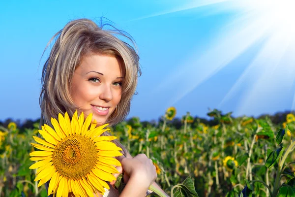 Mädchen mit einer Blume in der Sonnenblume — Stockfoto