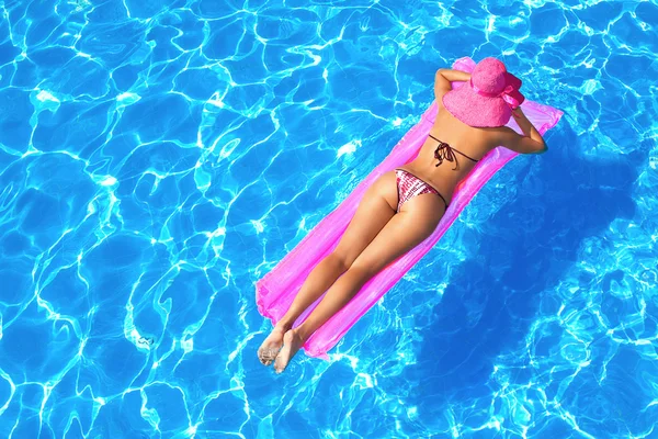 Sexy girl floating on a mattress in the sea or swimming pool — Stock Photo, Image