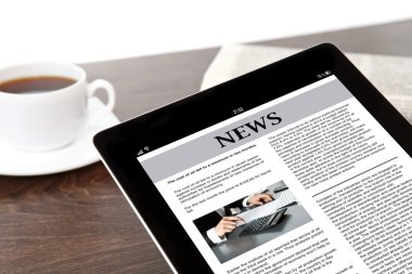 bir işadamı bir masada ekranda iş haberleri ile tablet