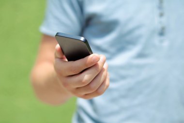 yeşil bir duvara bir telefon tutarak çocuk