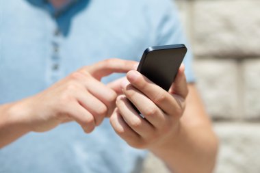 bir telefon ve dokunmatik ekran parmak için bir duvara tutan çocuk