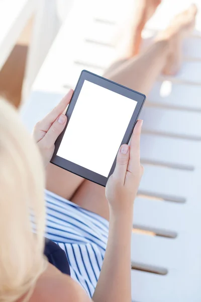 Meisje in een badpak liggend op een chaise lounge met een computer — Stockfoto