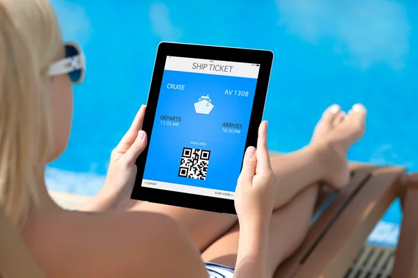 Menina deitada em uma cadeira de praia junto à piscina e segurando um tablet com — Fotografia de Stock