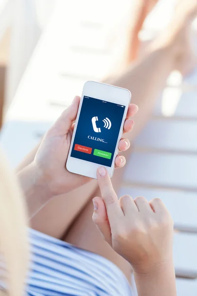 Ragazza in costume da bagno sdraiata su una chaise lounge con telefono touch — Foto Stock