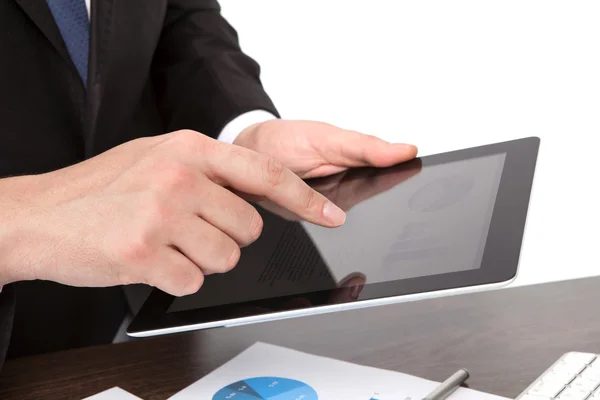 Businessman holding a tablet on the table with graphics — Stock Photo, Image