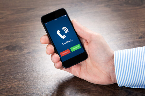 businessman holding a phone with blue screen and the phone ringi