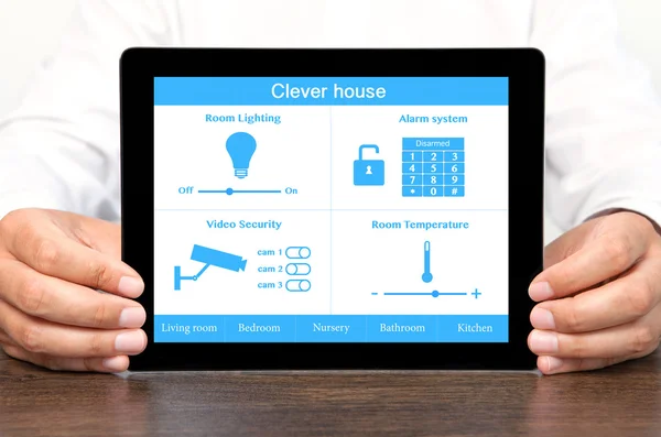 Empresário segurando um computador tablet com sistema inteligente casa — Fotografia de Stock