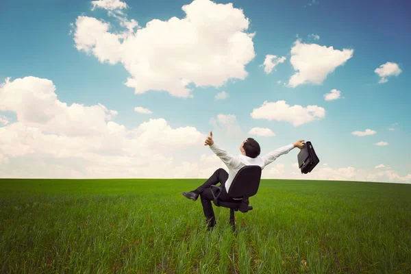 Бизнесмен в поле с голубым небом сидит на офисном чае — стоковое фото