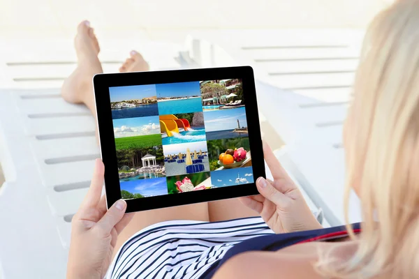 Girl in a bathing suit lying on a chaise lounge with a tablet an — Stock Photo, Image