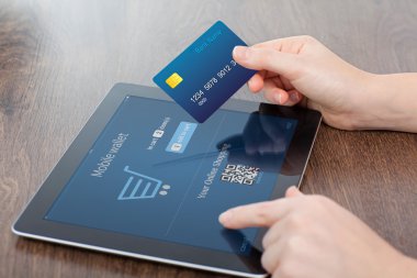 kredi kartı ve bir tablet ofiste tutan eller ve 