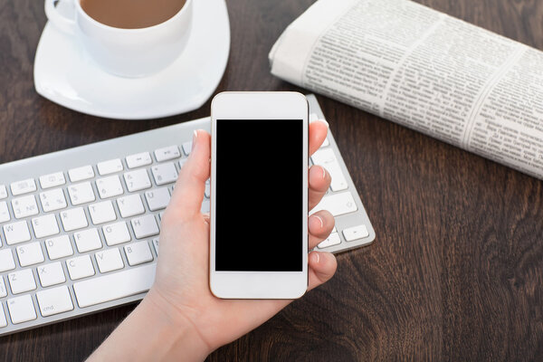 businesswoman hand holding a phone with against the background o