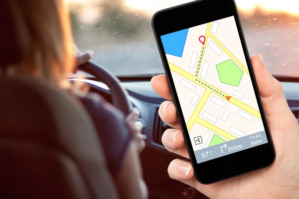 Fahrerin hält ein Telefon mit Interface-Navigator in der Hand — Stockfoto