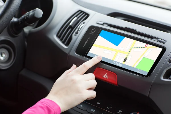 Žena sedí v auta a dotykové hry prst do navigační mapy — Stock fotografie
