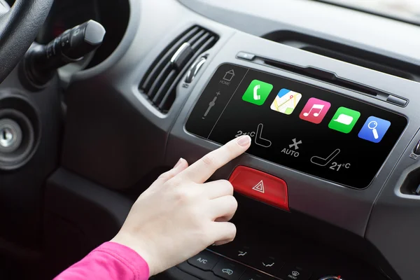 Kvinna sitter i en bil och touch spela finger i en auto smart sys — Stockfoto