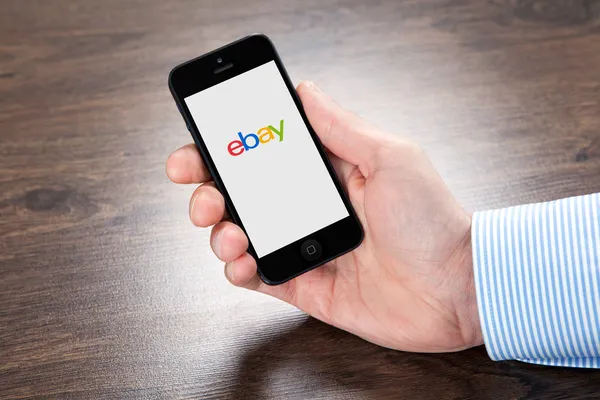 Empresário segurando iPhone com eBay na tela sobre o vill — Fotografia de Stock