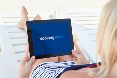 havuz kenarında yalan ve ipad app Booking üzerinde tutan kız