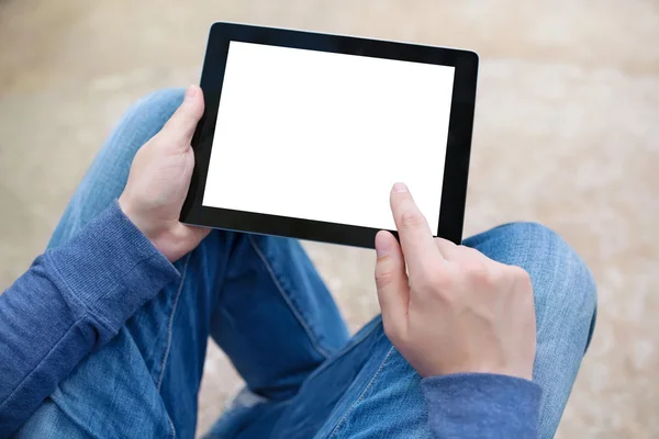 Чоловік сидить у парку і тримає планшет з ізольованим екраном — стокове фото