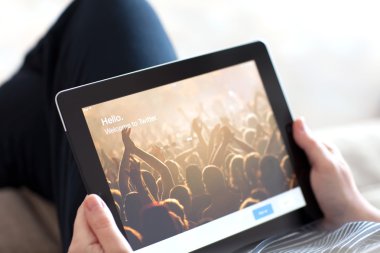 kanepede oturan ve ipad app twitter ile t üzerinde tutan kadın