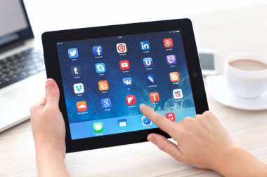 Female hands holding iPad with social media app on the screen in clipart