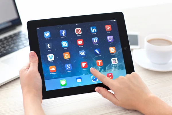 Mani femminili che tengono iPad con app di social media sullo schermo in — Foto Stock