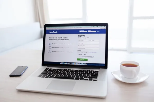 MacBook Pro Retina with Facebook home page on the screen stands — Stock Photo, Image