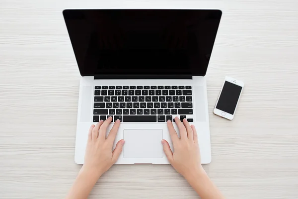 Mujer sentada en el MacBook Pro Retina y iPhone 5s — Foto de Stock