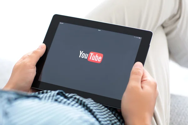 Homem segurando iPad com aplicativo YouTube na tela — Fotografia de Stock