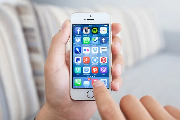 Man met een witte iphone 5s met sociale media netwerkprogramma — Stockfoto