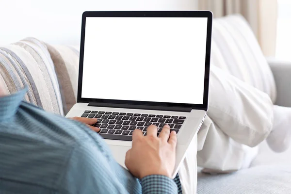 Homme couché sur le canapé dans la chambre et tapant sur un clavier d'ordinateur portable — Photo