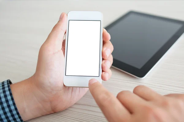 Hombre sosteniendo un teléfono móvil con pantalla aislada sobre la mesa — Foto de Stock