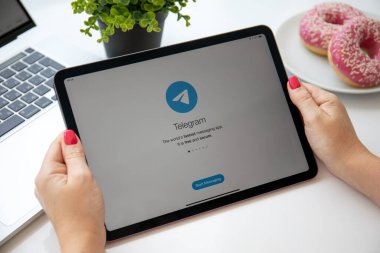 Alanya, Türkiye - 6 Ağustos 2021: Kadın el ele tutuşan iPad Air Space Gray ile sosyal ağ servisi Telegram ekranda.