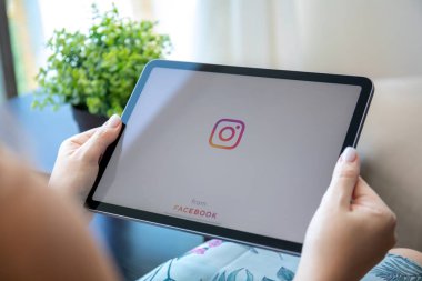 Alanya, Türkiye - 30 Eylül 2021: Kadınlar ekranda sosyal ağ hizmeti Instagram ile iPad Air ile el ele tutuşuyorlar